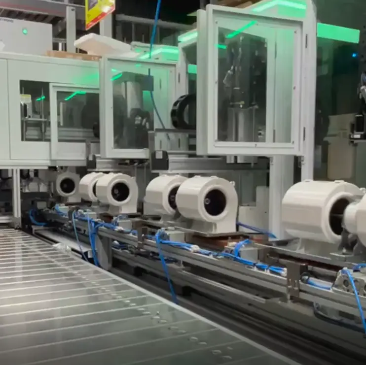 Automated fastening equipment line for motor assembly, showing multiple motor housings moving through a conveyor based screw fastening station